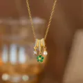Nahaufnahme einer eleganten Goldkette mit grünem Blumenanhänger, Zirkon und Perlendetail - Perlen-Grüne Blumen-Halskette (9317) / Gold
