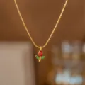 Makro-Detailansicht der eleganten goldenen Rosenanhänger-Halskette mit roten und grünen Zirkonia - Rote Tulpe Halskette / Gold