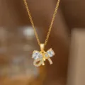 Vergoldete Schleifenkette mit funkelnden tropfenförmigen Zirkonia-Kristallen, Nahaufnahme. - Schleife Stil (9415)