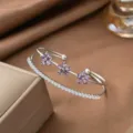 Nahaufnahme eines silbernen Armreifs mit lila Blüten und Zirkonia - Drei Lila Strass Blumen (E2907) / Silber