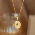 Primer plano de un colgante de relicario ovalado dorado de estilo vintage con estrella negra. - Dorado (Estrella Ovalada)