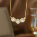 Elegante goldene Halskette mit drei runden, funkelnden weißen Zirkonia-Anhängern. - Drei Weiße Strass-Runden (9310) / Gold