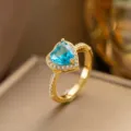 Eleganter herzförmiger Ring mit blauem Zirkonia, Goldband und glitzerndem Mikropflaster - Nur Ring (F1279) / Einstellbar Offen / Hellblaues Herz (Gold)