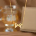 Detailansicht einer eleganten goldfarbenen Halskette mit einem feinen Schleifenanhänger - Glänzende Schleife (9395)