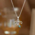 Detaillierte Nahaufnahme einer silbernen Schleifenkette mit Herzanhängern in Blau - Blaue Zirkonia Herz Schleife Halskette (9418)