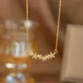 Nahaufnahme einer goldfarbenen Halskette mit einer Reihe von funkelnden Kristallblumen - Sechs Kleine Blumen (9401)