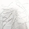 White ribbon bow detail shot for cake decoration, gift wrapping and festive crafts. - White