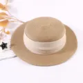 Beige Strohhut mit flacher Krone, breiter Krempe und Stoffband, stilvoller Sonnenschutz. - Flachdeckel-Hut in Hellbraun mit beigem Band