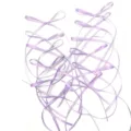 Detailed close-up view of light purple ribbon bows with long tails for cake baking decoration. - Purple