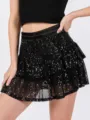 Detailed view of the black sequinned tiered mini skirt, featuring shiny sequins and mesh layers. - S / Bottoms / Black