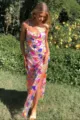 Nahaufnahme Detail des floralen Pailletten-Slip-Kleids mit Goldkettenträgern und Schlitz. - S / Rosa
