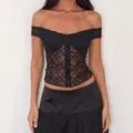 Nahaufnahme Detail des schwarzen schulterfreien Spitzenkorsetts mit transparentem Muster. - S / Schwarz