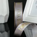 Nastro in raso grigio con stampa lamina d'oro, ideale per confezioni regalo e decorazioni. - Grigio