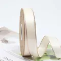 Primer plano detallado de un rollo de cinta de poliéster con borde dorado para regalos. - Talla 25 / Blanco Roto