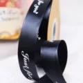 Primer plano detallado de cinta de poliéster negra con texto blanco para envolver regalos. - Grande Negro