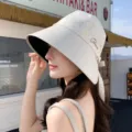 Summer sun protection bucket hat for women with wide brim and elegant back bow strap design. - Off White