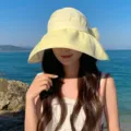 Detailansicht des stilvollen gelben Sonnenhuts mit süßer Schleife für den Strand im Sommer. - Gelb