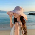 Detailansicht der breiteren Damen-Sonnenschutz-Leerkappen mit Schal in Rosa am Strand. - Rosa