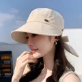 Dettaglio di cappello da sole beige da donna con fiocco posteriore e dettaglio in metallo. - Beige