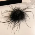 Close-up detail of fluffy black ostrich feather hair claw clip for elegant hairstyles. - Black Ostrich Feather - Medium Half-up Hair Claw