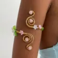 Dettaglio di un bracciale da braccio a spirale dorato con fiori in acrilico e pietre - Bracciale Da Braccio Con Fiori