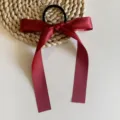 Détail d'élastique à cheveux en ruban de satin bordeaux, nœud élégant pour coiffures. - Bordeaux