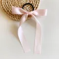 Détail de l'élastique à cheveux en ruban satin rose, joli nœud long pour coiffure douce et quotidienne. - Rose Clair