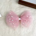 Close-up detail of the pink mesh pearl bow hairpin, showing delicate tulle and white beads. - Pink