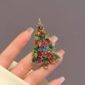 Vue détaillée d'une broche sapin de Noël dorée antique avec strass multicolores. - Y0005-1 Broche de Sapin de Noël