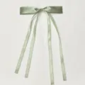 Detailed shot of a sage green satin ribbon bow hair clip, featuring elegant double trailing ribbons. - Polyester Material: Matcha Green