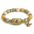 Dettaglio di un bracciale vintage in cristallo con ciondolo ape dorato e perla floreale. - Bracciale Ape Verde