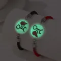 Gros plan de bracelets de couple lumineux en acier inoxydable avec pendentifs cœur - Style Lumineux Couple