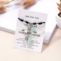 Detailansicht von Halloween-Spinne-Paararmbändern mit grünen Perlen auf Geschenkkarte. - Schwarz Weiß Geflochtenes Seil Spinne Stil (BR23Y0527)