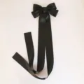 Black satin bow hair clip detail, featuring an oversized design with long flowing ribbons. - Duckbill Hair Clips / Black