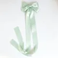 Close-up of mint green satin bow hair clip with long flowing ribbons, elegant hair accessory detail - Duckbill Hair Clips / Green