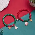 Vue détaillée de bracelets de Noël en perles rouges et vertes avec breloques Père Noël. - Style Père Noël
