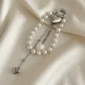Vista dettagliata di un elegante ciondolo per borsa in perle con cuori metallici chic - Stile Cuore con Nappa Argento (XK26Y0511)