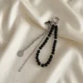 Dettaglio di un elegante ciondolo per borsa con perle nere e moneta d'argento - Stile Moneta Regina Catena Spessa Nera (XK26Y0513)