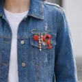 Close-up of fashion brooch with lobster, rose, and seahorse charms on denim jacket. - Red Flower Lobster Seahorse Style (26Y0004)