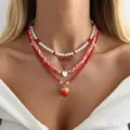 Detailansicht von rot-weißen Halsketten mit Erdbeer-, Herz- und Schleifenanhängern im Lagenlook. - Rot-Weißes Herz Erdbeere 3-Lagen Set (NC25Y0978)