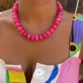 Close-up detail of a bright pink resin beaded necklace worn in a trendy bohemian style - Rose Red