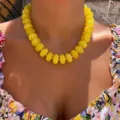 Vibrant yellow resin beaded choker necklace in Bohemian style worn on a floral dress - Yellow