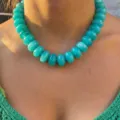 Detailed view of a bohemian chunky turquoise resin beaded necklace worn on a model neck - Emerald