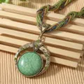 Detailed macro view of bohemian vintage necklace featuring a green stone and woven cord - Dark Green