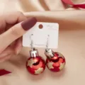 Red metallic Christmas ball drop earrings featuring gold glitter stars shown on display card - Red and Gold Star Christmas Ball Earrings (4#ER21Y0621-1)