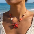 Primo piano di una collana con ciondolo a stella marina e conchiglia indossata da una modella - Parure collana e orecchini