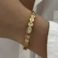 Detailansicht eines goldenen Edelstahlarmbands mit edlen Markise- und Rundkristallen - Gold (Multi-Form Strass-Stil)