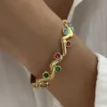 Close-up van gouden roestvrijstalen armband met veelkleurige stenen en gedraaid design - Goud (Hol Slang Gedraaid Meerkleurige Edelsteen)