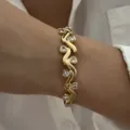Detailopname van retro vergulde roestvrijstalen armband met hartvormige kristallen - Goud (Gedraaid Onregelmatig Hart Strass)