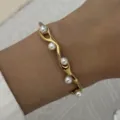 Elegante gouden golvende roestvrijstalen armband met kleine witte parels om de pols - Goud (Golf Hol Multi-Parel Versierd)